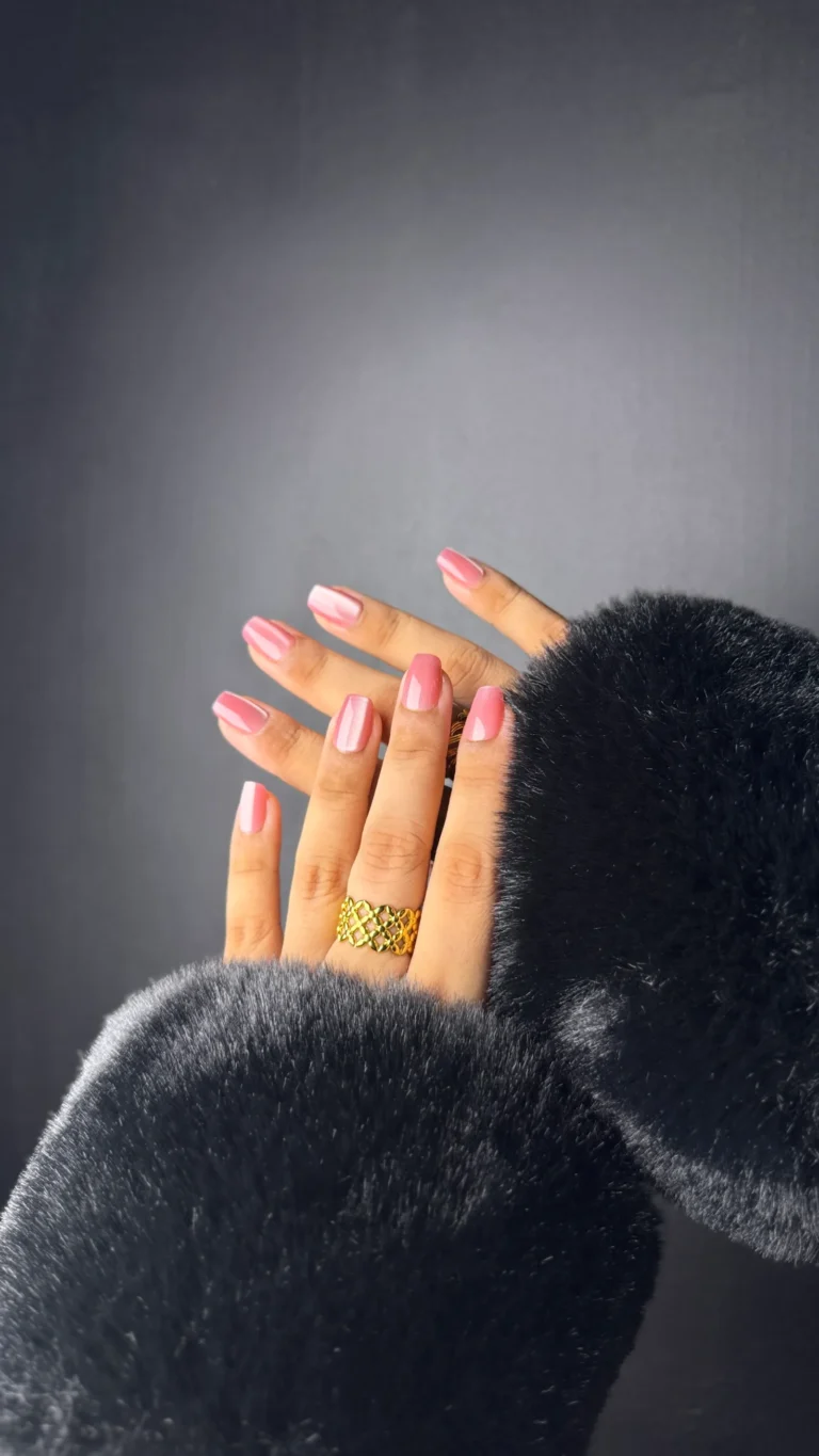 Short pink press-on nails with a black fur sleeve
